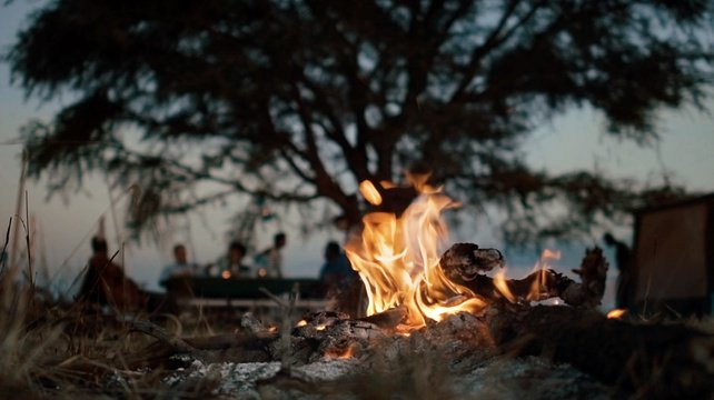 The campfire still burns as morning breaks, after your night camping in the kraal, Karamoja, Uganda.