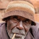 A portrait of a man smoking a pipe at Lake Bunyonyi, Uganda