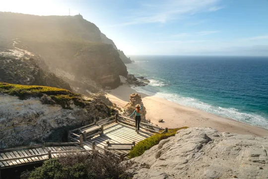 Steps leading down to a sheltered beach below coastal cliffs