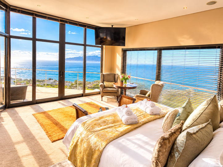 Sea-facing Aqua Terra bedroom with a king bed and seating beside large windows