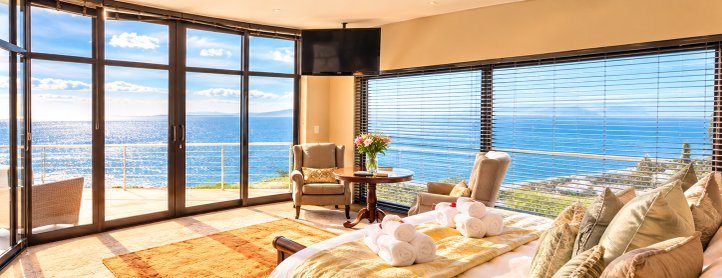 Sea-facing Aqua Terra bedroom with a king bed and seating beside large windows