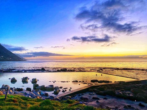 Coastal bay and beach beneath a colourful evening sky