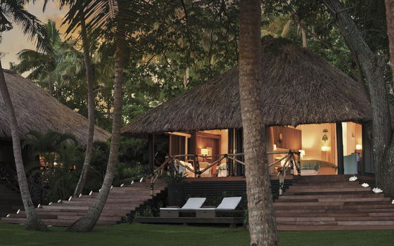 Exterior of a guest bure surrounded by lush tropical gardens at Dolphin Island