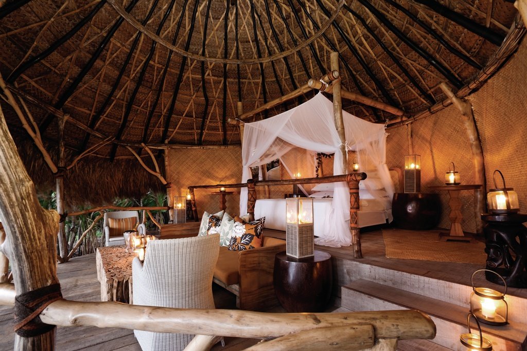 Hilltop sleep-out with a canopy bed overlooking tropical ocean at Dolphin Island