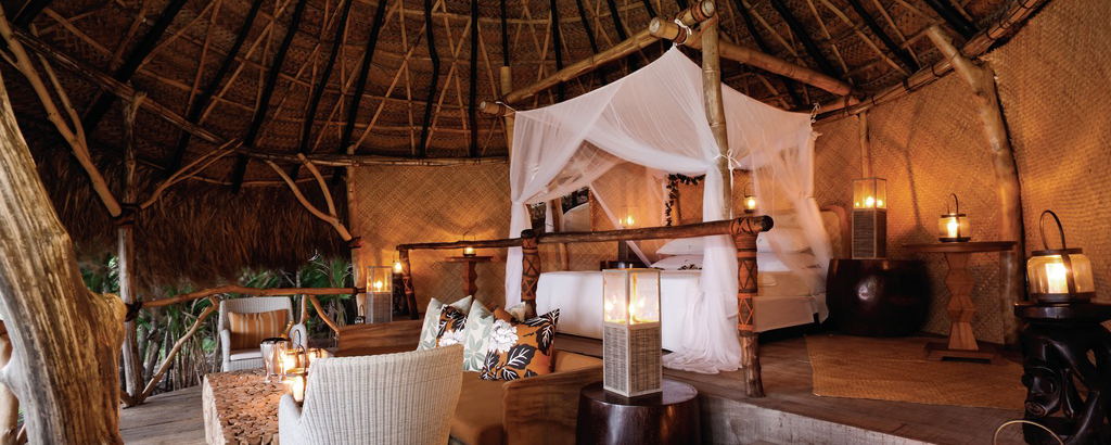 Hilltop sleep-out with a canopy bed overlooking tropical ocean at Dolphin Island
