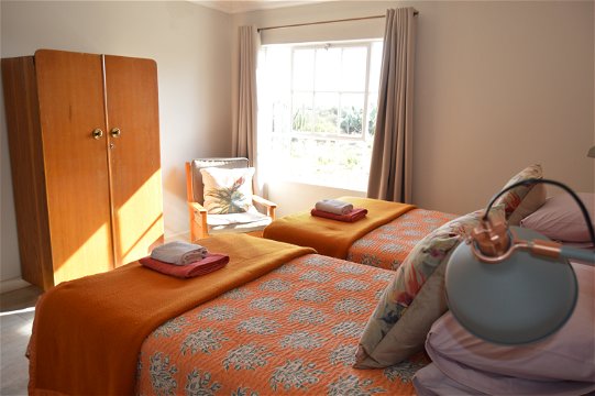 sonnige slaapkamers met stoel en klerekas asook spieeltafel