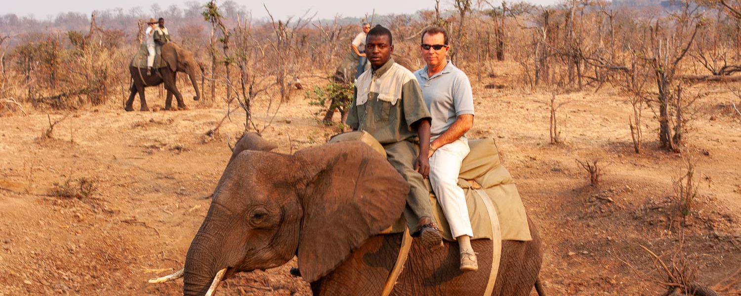 Neville Jones of Experiential Travel rides an elephant in Zimbabwe