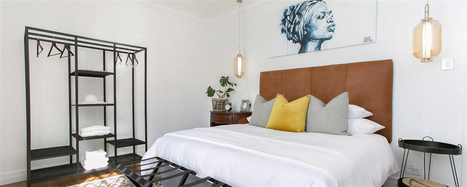 Master bedroom with King XL bed, loose wardrobe, hanging ceiling lights, overhead African Art at La Maison On Main Self-Catering Villa, Paarl