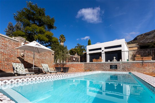 View of sun loungers next to lap pool at La Maison On Main in Paarl.