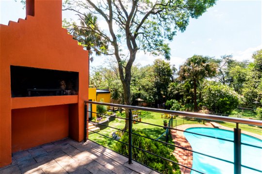  beautifully designed braai area in a guesthouse with built-in grill, seating and surrounded by natural views, perfect for a traditional South African barbecue experience.