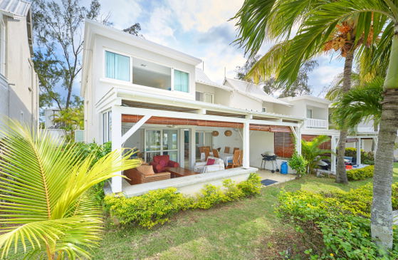 Front view of villa with balcony and tropical landscaping