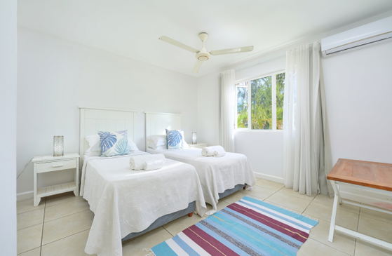 Twin bedroom with ocean-themed bedding and bright window