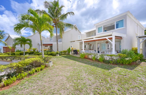 Two-story villa with balcony and tropical garden