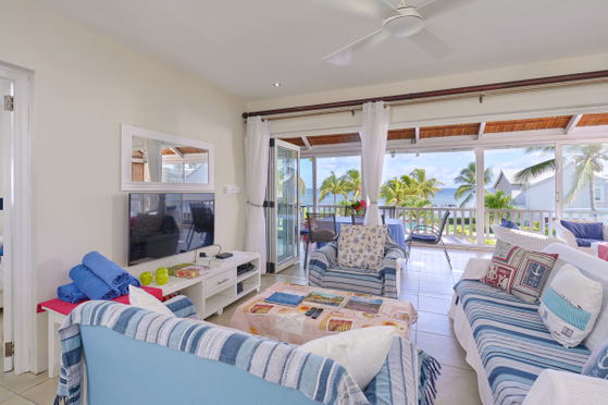 Indoor-outdoor seating area with striped sofas and sea views