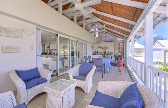 Indoor-outdoor seating area with striped sofas and sea views