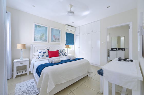 Bright bedroom with blue coastal decor and ceiling fan