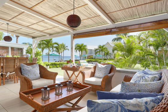 Covered dining patio with woven chairs and ceiling fan