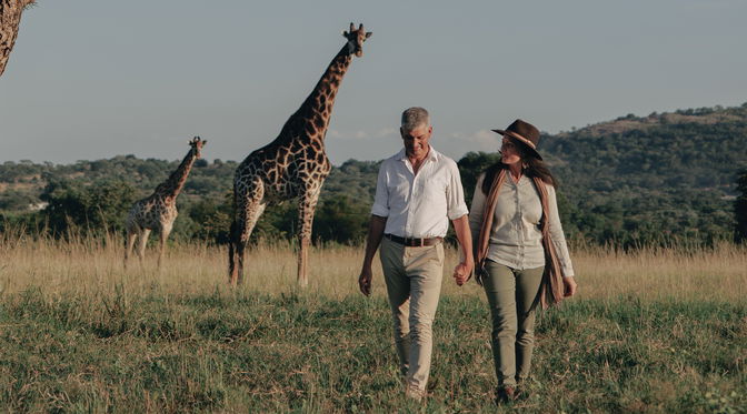 Hylton Langley Safaris Couple standing in front of a giraffe