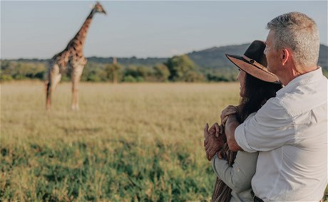 Honeymooners sharing a special moment with a giraffe in South Africa.