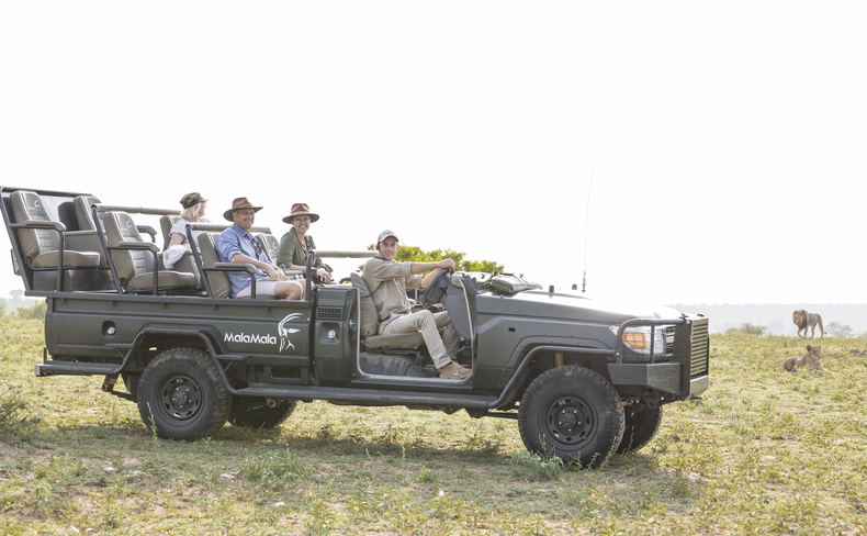 Guests on safari at MalaMala Game Reserve observing lions Guests on safari at MalaMala Game Reserve observing lions