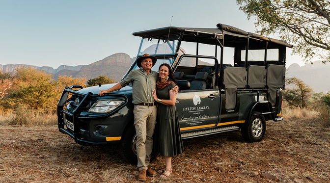 Couple standing in front of Hylton Langley Safaris Open Vehicle