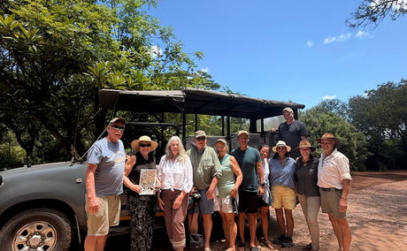 Group of guests in front of safari vehicle with safari guides Group of guests in front of safari vehicle with safari guides