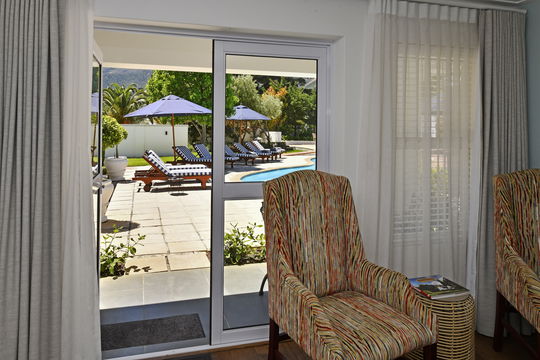 Elegant ensuite bedroom overlooking our beuatiful outside pool in Franschhoek