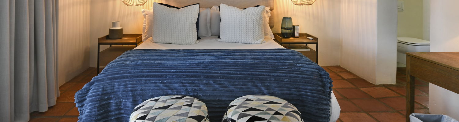 Bright bedroom with terrace overlooking the pool and garden at our boutique guesthouse in Franschhoek