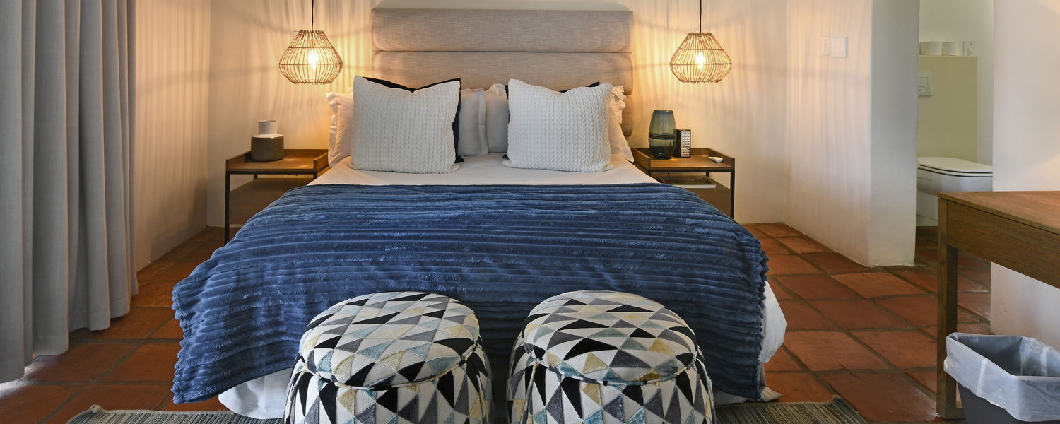 Bright bedroom with terrace overlooking the pool and garden at our boutique guesthouse in Franschhoek