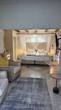 elegant suite where a canopy bed meets refined, cozy seating. The tasteful design and warm ambiance create a welcoming retreat for ultimate relaxation.