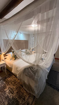 romantic safari suite, canopy bed with netting, cozy lodge retreat, elegant bush accommodation, intimate safari stay, stylish bedroom design, tranquil escape, comfortable safari lodging