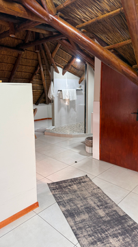 Kruger Riverside Lodge, Marloth Park, DCC Hotel Group, loft bathroom, thatched roof design, stone shower, rustic charm, safari lodge style