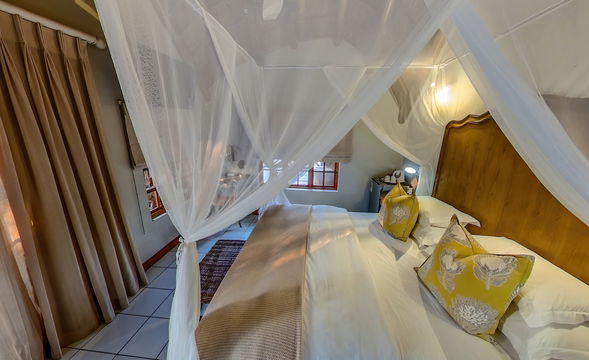 Graceful room draped with romantic mosquito netting. Soft hues and elegant details create a tranquil retreat that reflects the lodge’s timeless charm.