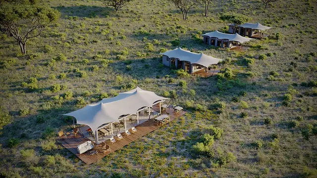 Experience the charm of a hillside retreat, where cozy tents blend harmoniously with the natural surroundings, offering a serene escape in a rural setting.
