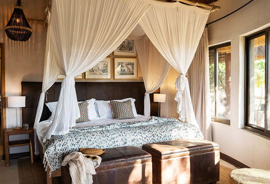 Simbavati Amani Lodge offers elegant canopy beds with stylish furnishings, creating a cozy and tranquil retreat for guests.