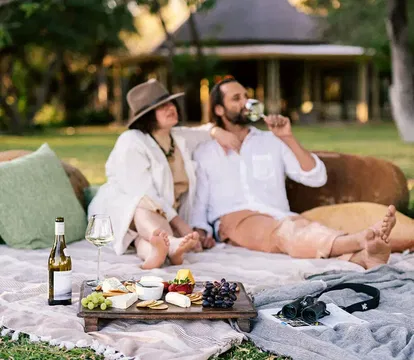 Simbavati Camp George provides a relaxed, outdoor setting perfect for casual gatherings, where guests can enjoy food and drinks surrounded by lush grass and a tranquil natural environment.