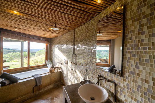 Escape to Gondwana Game Reserve, where luxury and nature combine. Enjoy stunning views from your spacious bathroom, perfect for soaking in the beauty of the wild during your stay.