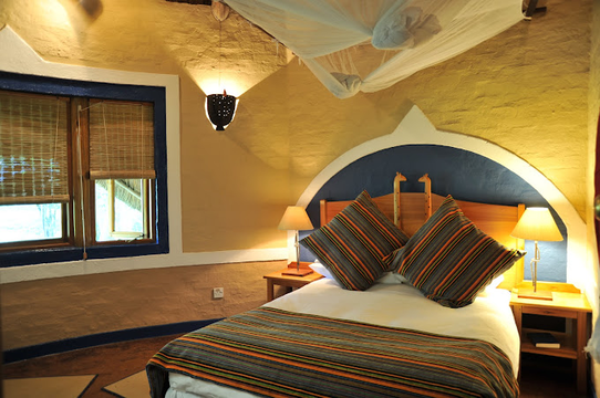 Indulge in the ultimate luxury at Victoria Falls Safari Club, where canopied beds and elegant design create the perfect retreat.