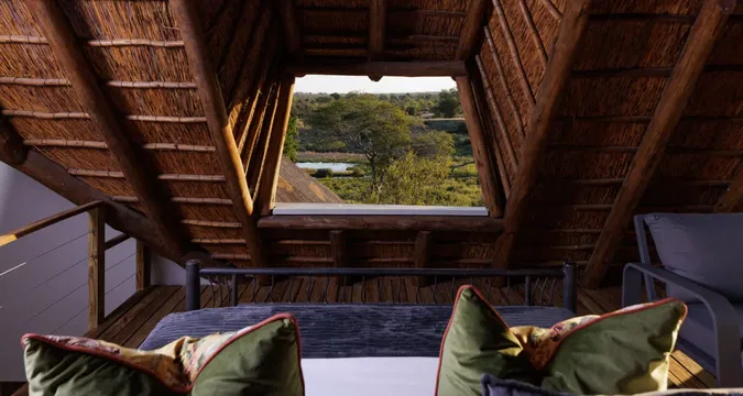 Simbavati Mvubu Cottage offers a serene retreat, with a cozy bed and natural light creating a peaceful atmosphere for relaxation.