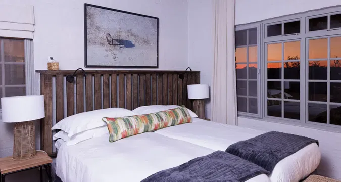 Simbavati Mvubu Cottage offers a cozy, relaxing space with natural light streaming in, perfect for unwinding on a comfortable bed.