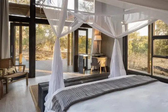 Relax in a serene sanctuary at Simbavati River Lodge, where soft lighting and refined linen create a calming space to unwind.