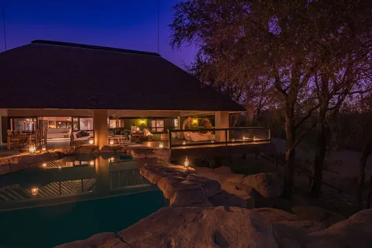 As night falls at Simbavati River Sands, the stillness of the pool and the warmth of the lodge offer pure relaxation.