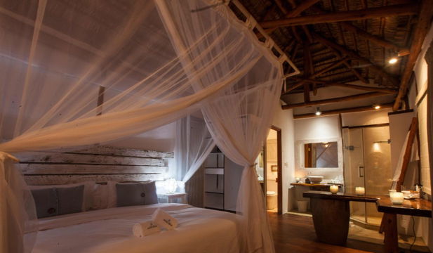 Vilanculos Beach Lodge offers stylish, cozy bedrooms with wooden accents, and a serene, beachfront ambiance.
