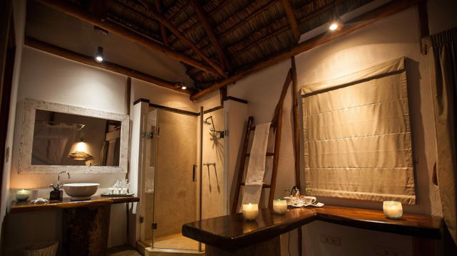 Vilanculos Beach Lodge features elegantly designed bathrooms with natural wood elements, creating a tranquil, nature-inspired retreat.
