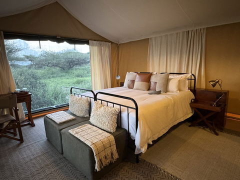 Enjoy a peaceful stay in a well-furnished bedroom, featuring comfortable beds, soft pillows, and a warm, inviting ambiance.
