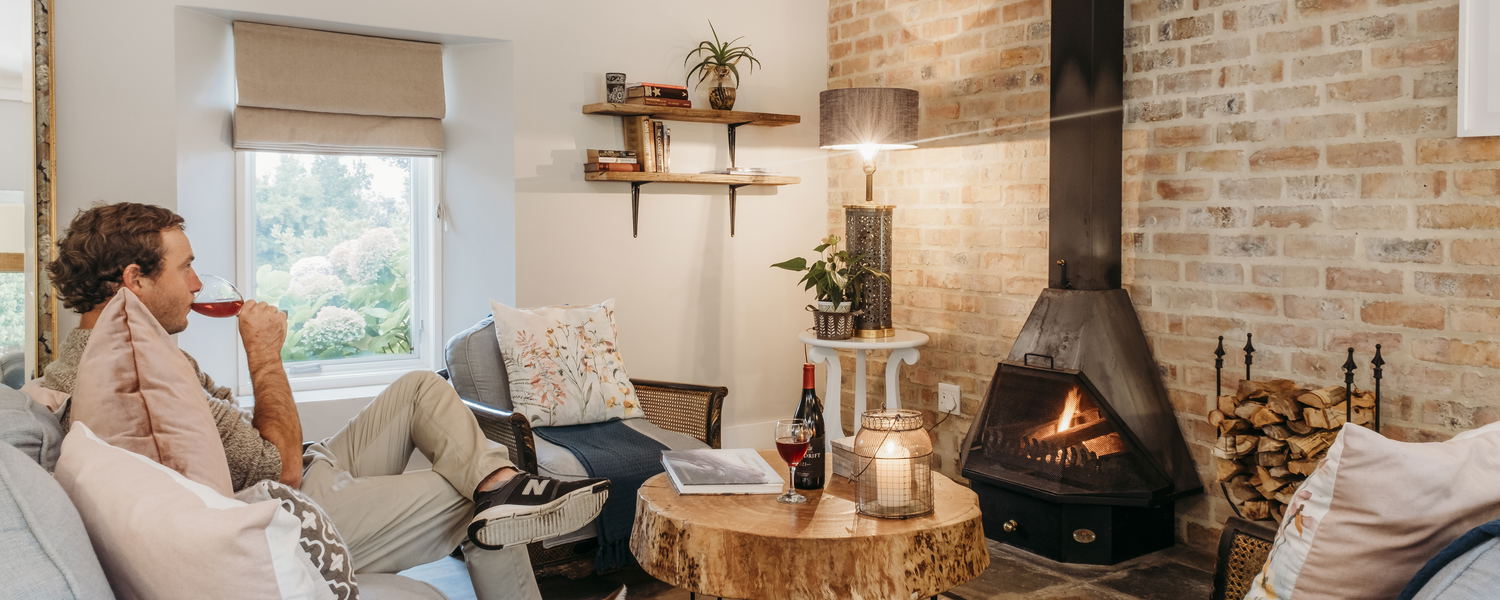a warm cozy lounge, sipping red wine in front of a fire on a winters getaway to White Water Farm
