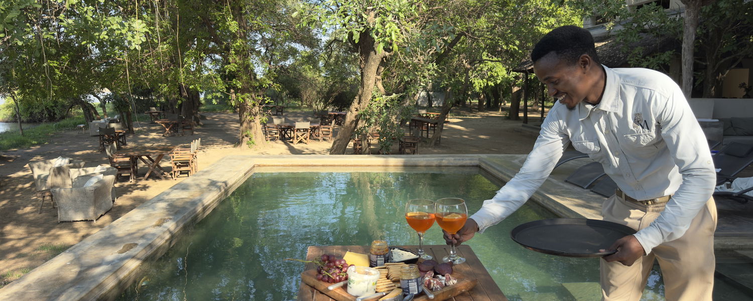 Sundowners at the pool at msandile river lodge zambia at the luangwa river