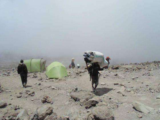 Every successful Kilimanjaro trek depends on a team working quietly behind the scenes. Porters carry essential equipment, set up camps, and make the journey possible. At Kijani Tours, porter welfare is central to responsible trekking. We believe the people who make your summit possible deserve fair treatment, proper equipment, safe working conditions, and respect. Your Kilimanjaro journey should benefit the people who help you reach the top. Every successful Kilimanjaro trek depends on a team working quietly behind the scenes. Porters carry essential equipment, set up camps, and make the journey possible. At Kijani Tours, porter welfare is central to responsible trekking. We believe the people who make your summit possible deserve fair treatment, proper equipment, safe working conditions, and respect. Your Kilimanjaro journey should benefit the people who help you reach the top.