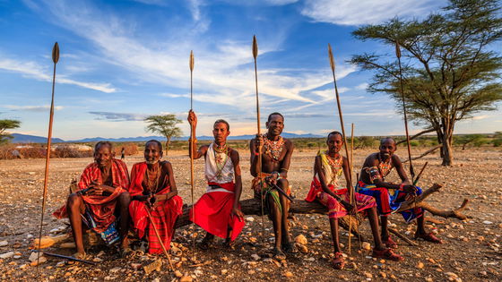 A group of culture african masai sitting holding spears during a safari in africa kenya uganda