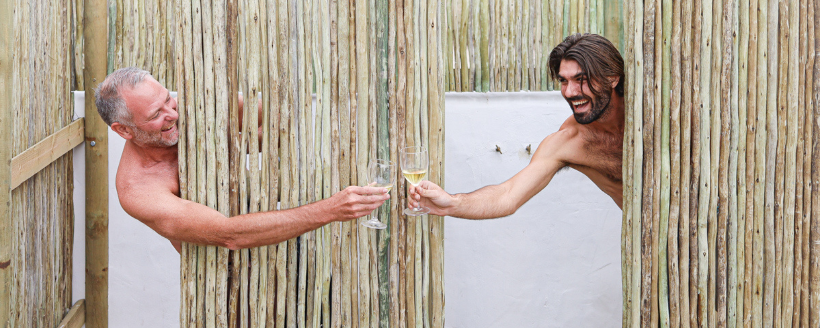 Image showing two people 'cheersing' at an outdoor shower at Gonana Collection in Paternoster | Jared in CT | Gonana Travel West Coast Tour